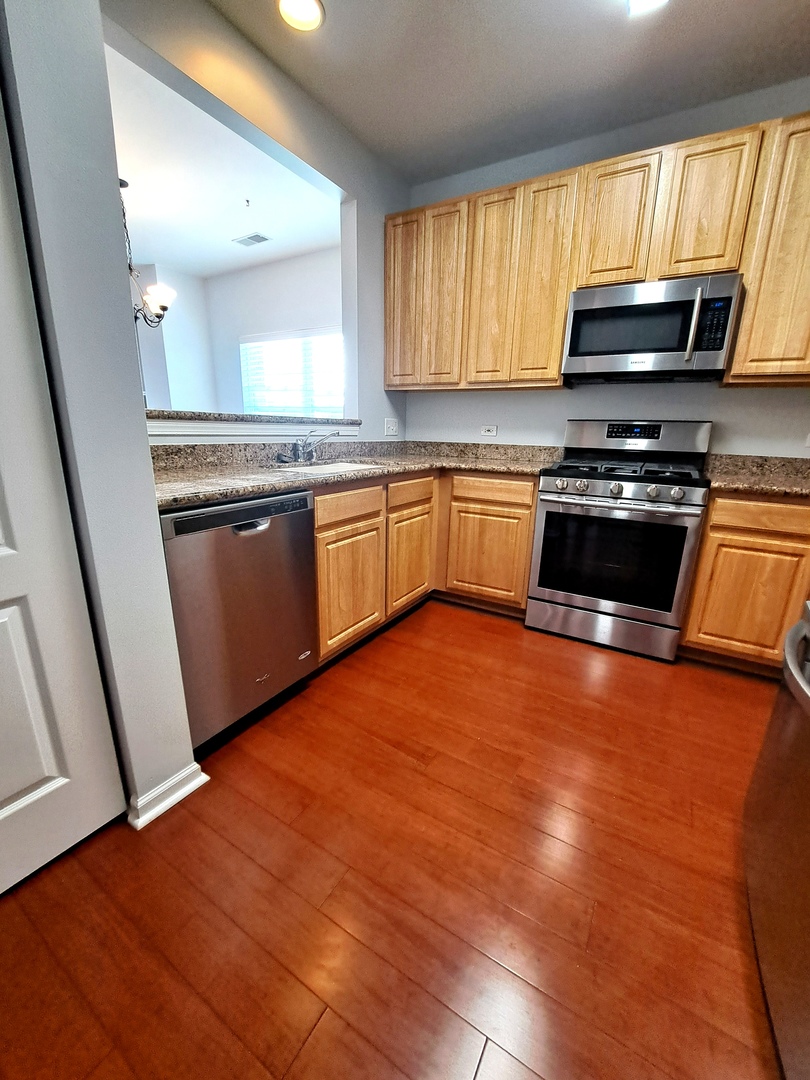1307 West Lake Street, Unit 304 Addison, IL 60101 - Photo 10 of 33 a kitchen with stainless steel appliances granite countertop a stove a sink and a microwave