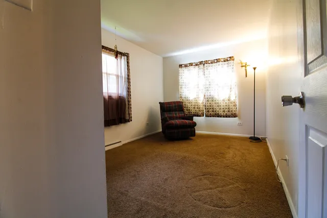 a view of an empty room with a fireplace and a window