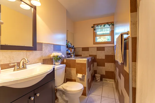 a bathroom with a granite countertop toilet sink and mirror