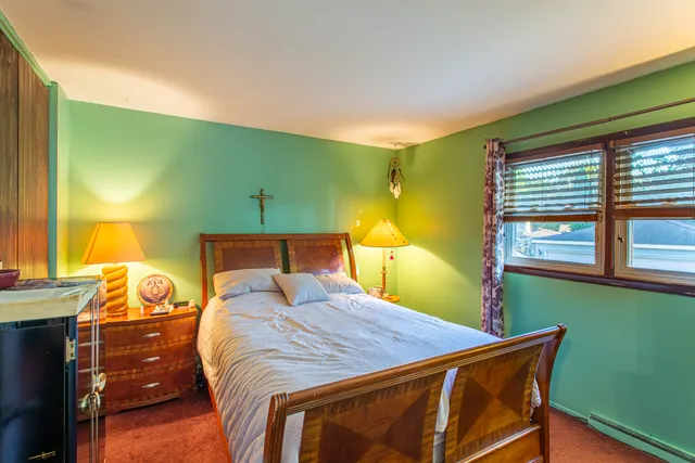 a bedroom with a bed and windows