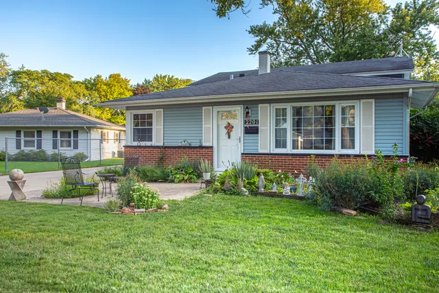 a view of a house with a yard and potted plants
