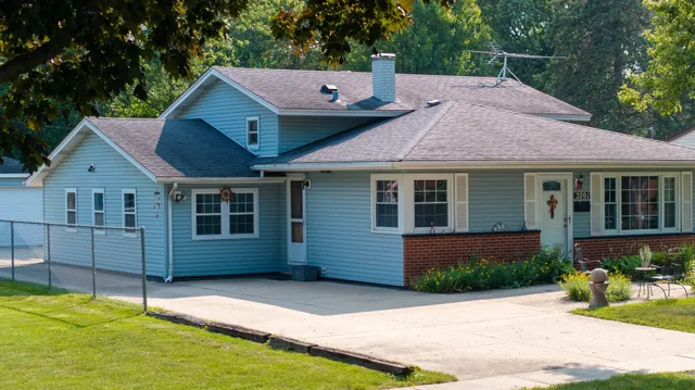 a front view of a house with a yard and potted plants
