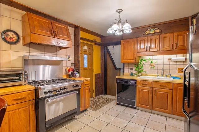 a kitchen with stainless steel appliances granite countertop a stove a sink and a refrigerator