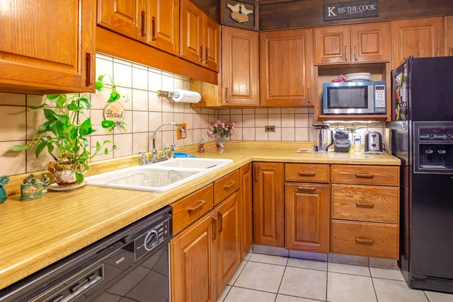 a kitchen with stainless steel appliances a sink cabinets and a window