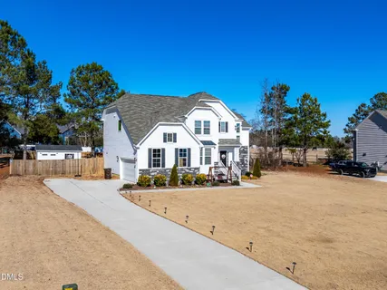 a view of a house with a yard and large trees
