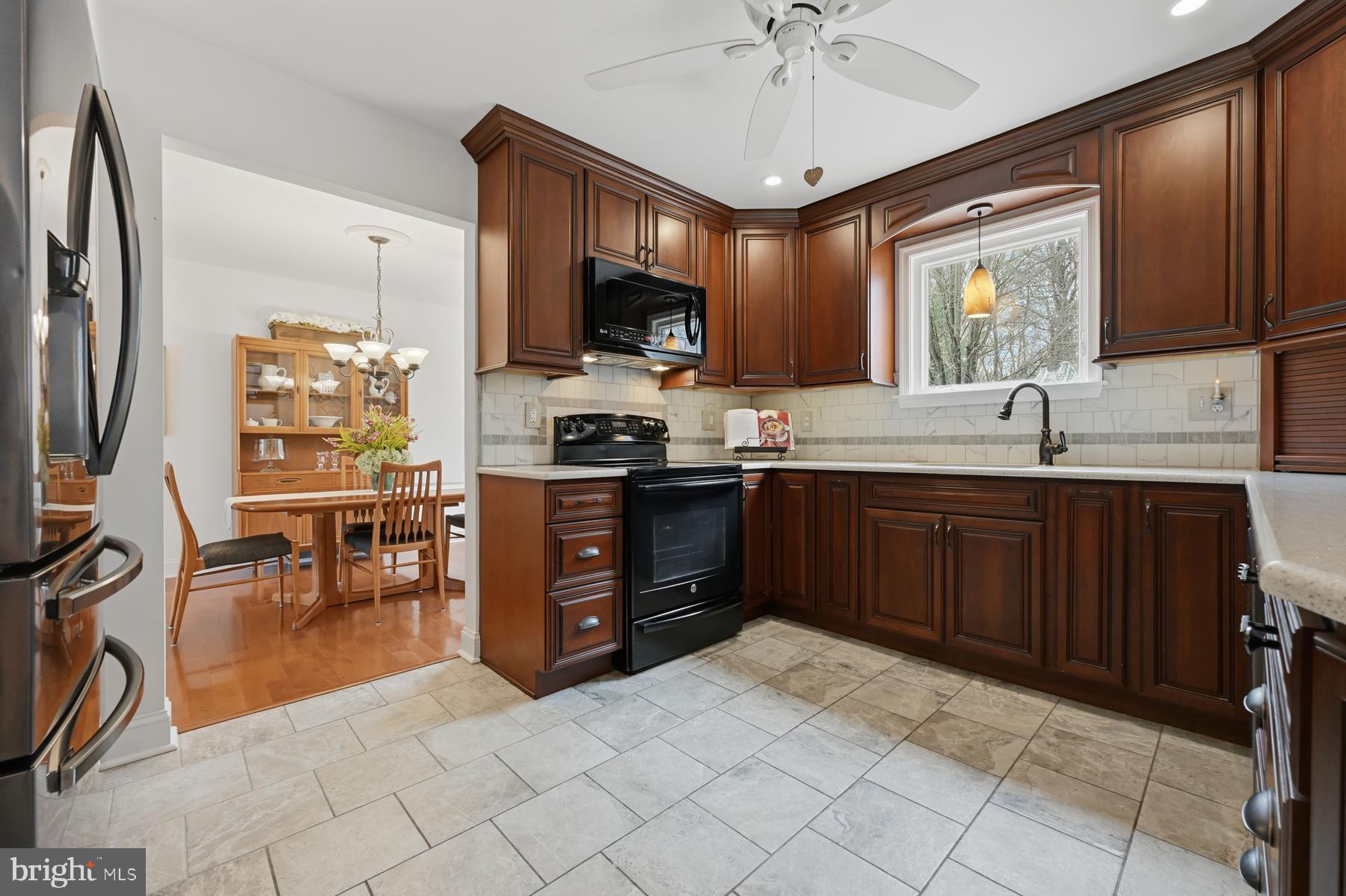 8329 Sail Court Pasadena, MD 21122 - Photo 11 of 61 a kitchen with stainless steel appliances granite countertop a sink counter space cabinets and a refrigerator