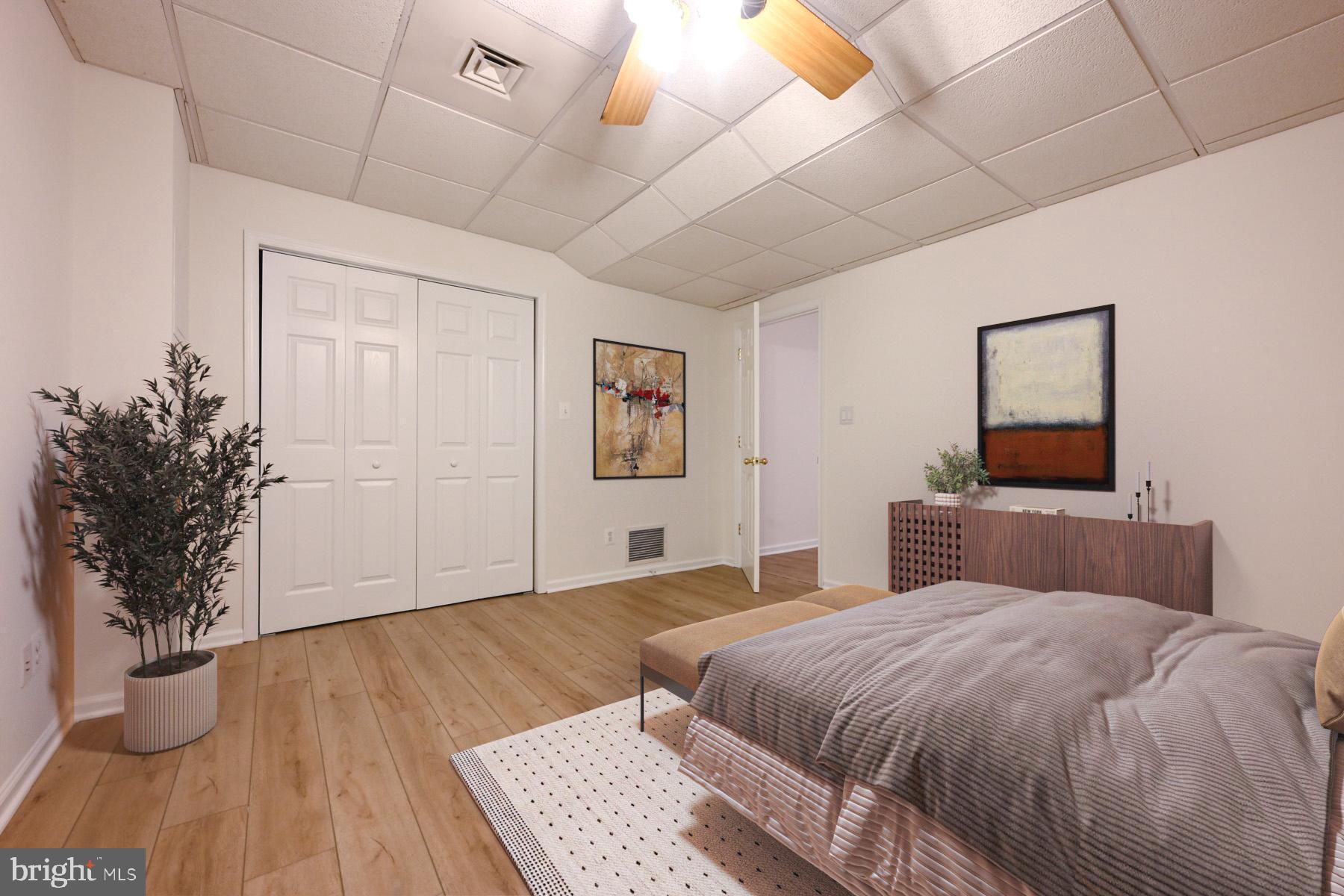 8329 Sail Court Pasadena, MD 21122 - Photo 42 of 61 a bedroom with a large bed and a wooden floor