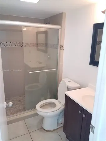 a white toilet sitting next to a shower