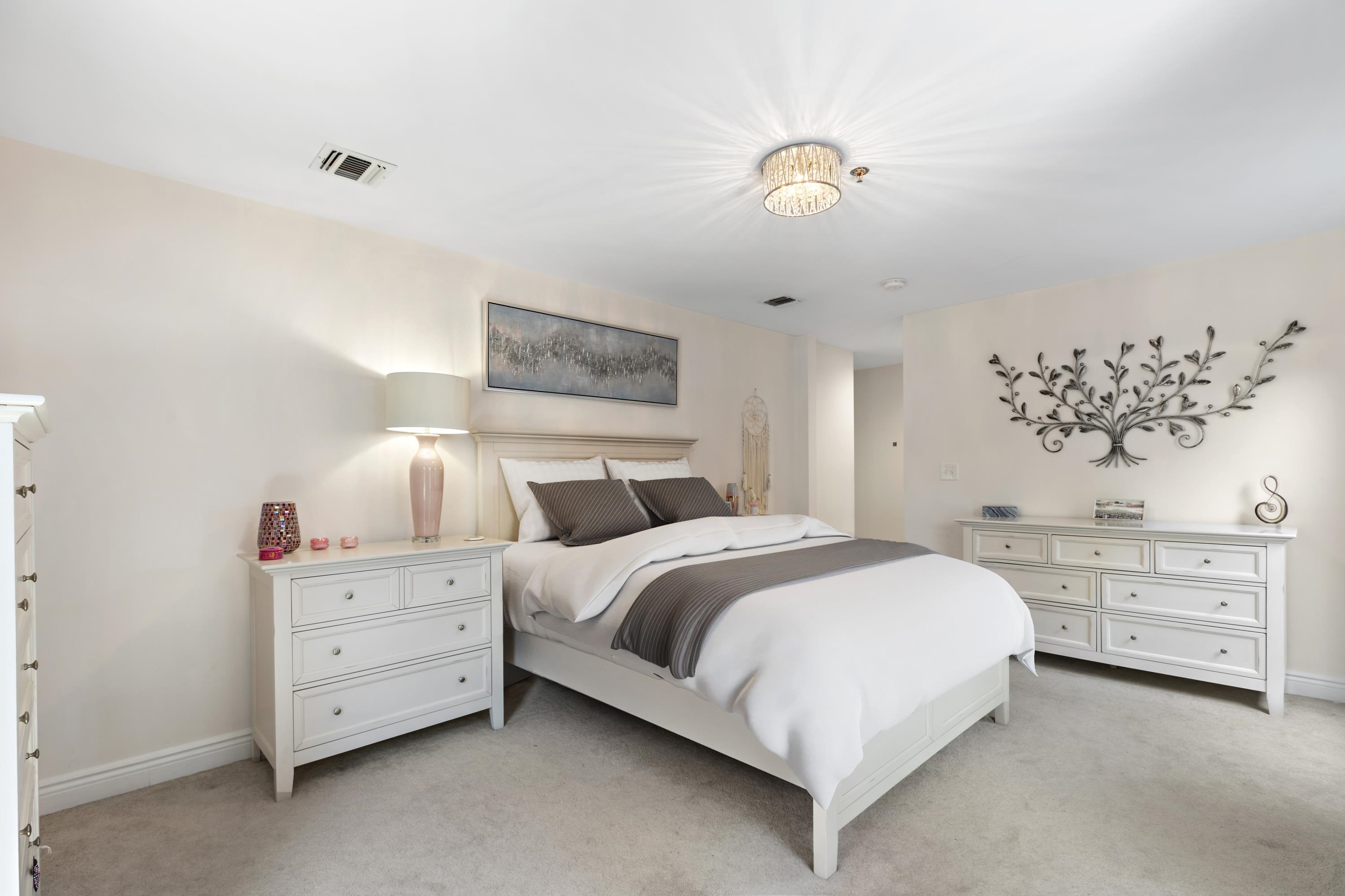 137 20th Street, Unit B Union City, NJ 07087 - Photo 13 of 33 a spacious bedroom with a bed and a chandelier