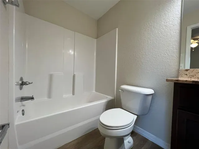 a white toilet sitting next to a bath tub