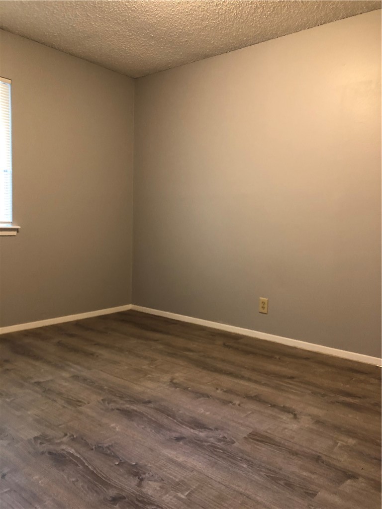 6502 South 1st Street, Unit 102 Austin, TX 78745 - Photo 14 of 26 a view of an empty room with wooden floor and a window