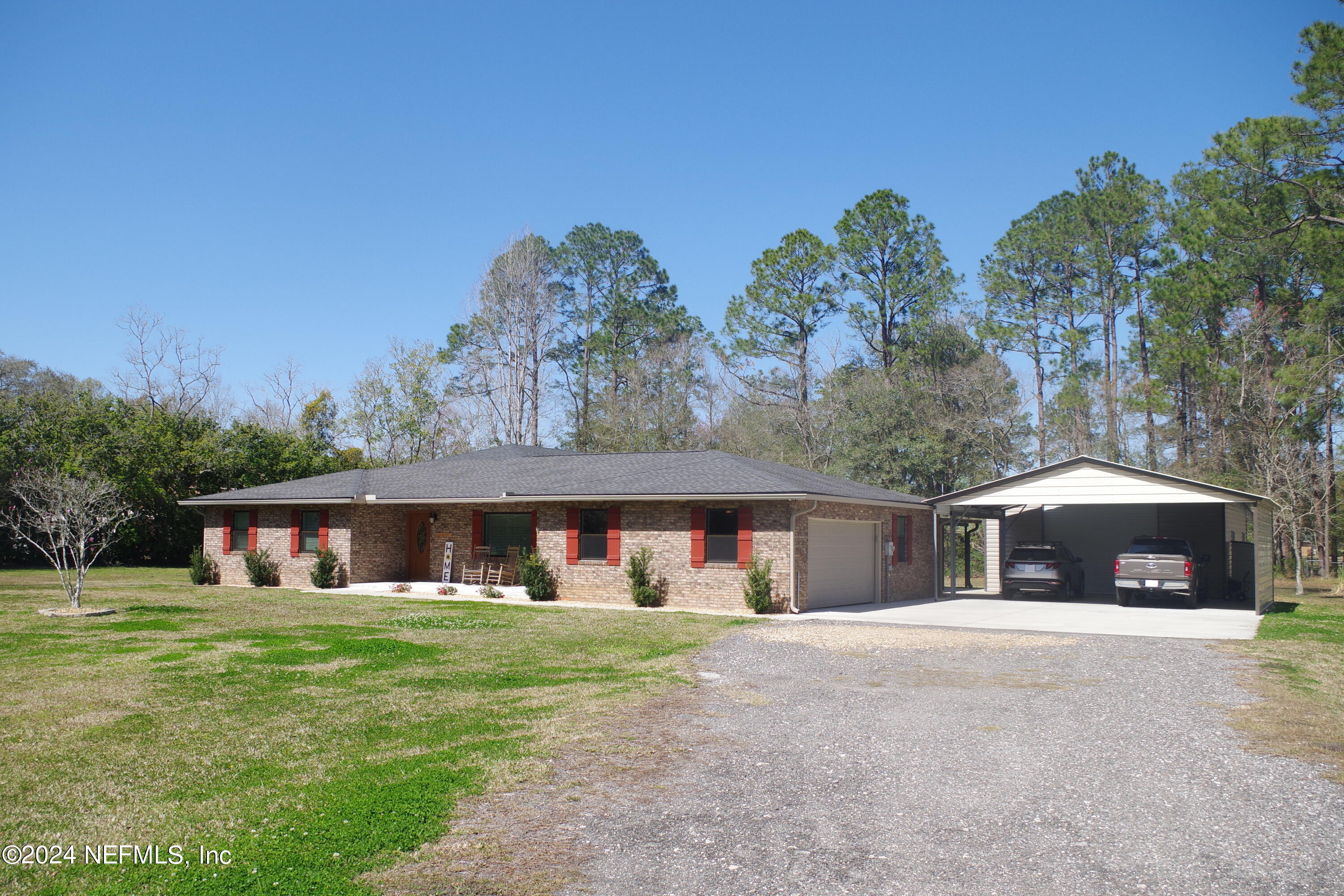 54065 Howard Road Callahan, FL 32011 - Photo 3 of 69 a front view of house with yard and trees in the background