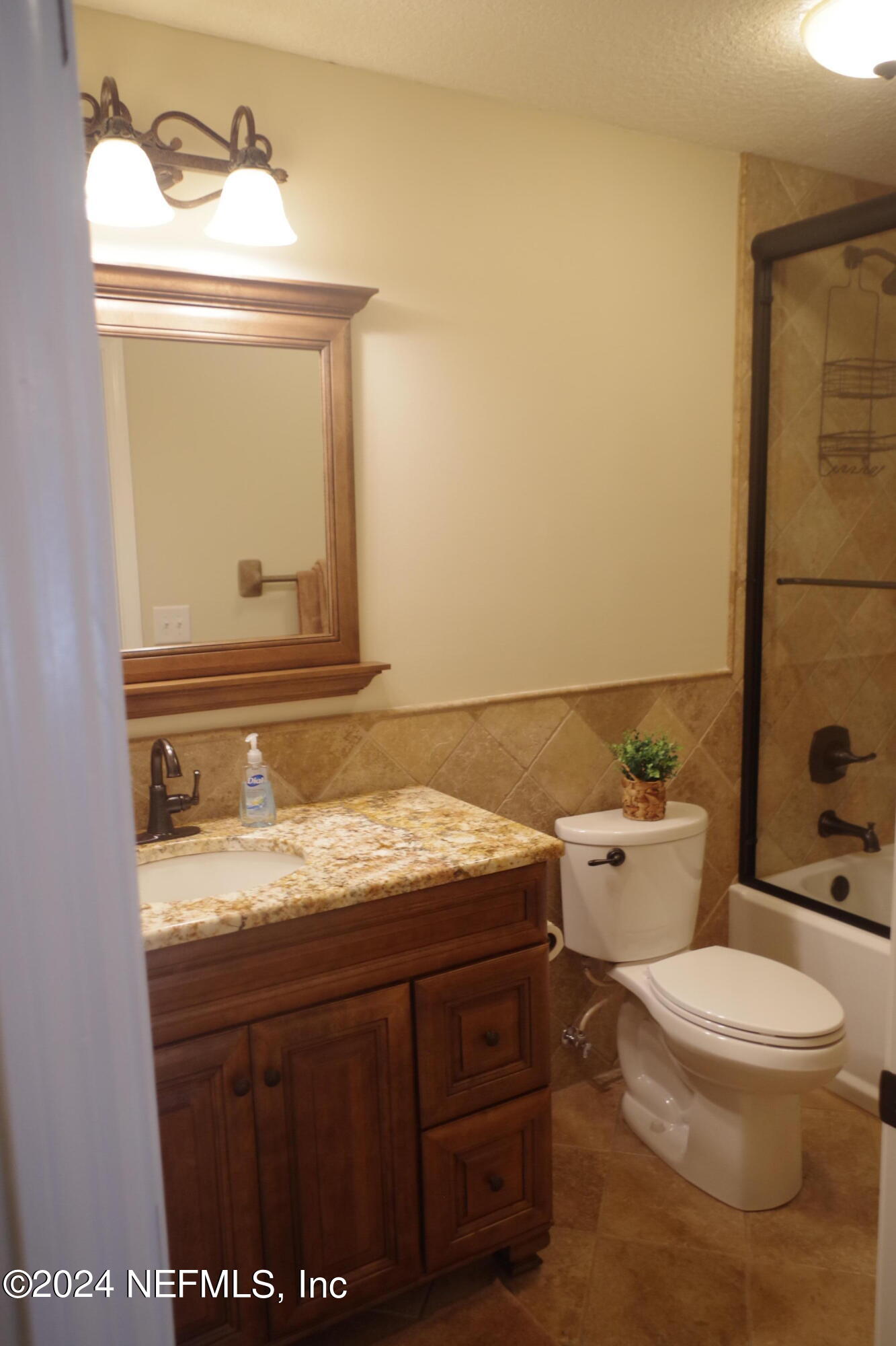 54065 Howard Road Callahan, FL 32011 - Photo 35 of 69 a bathroom with a granite countertop toilet sink and mirror