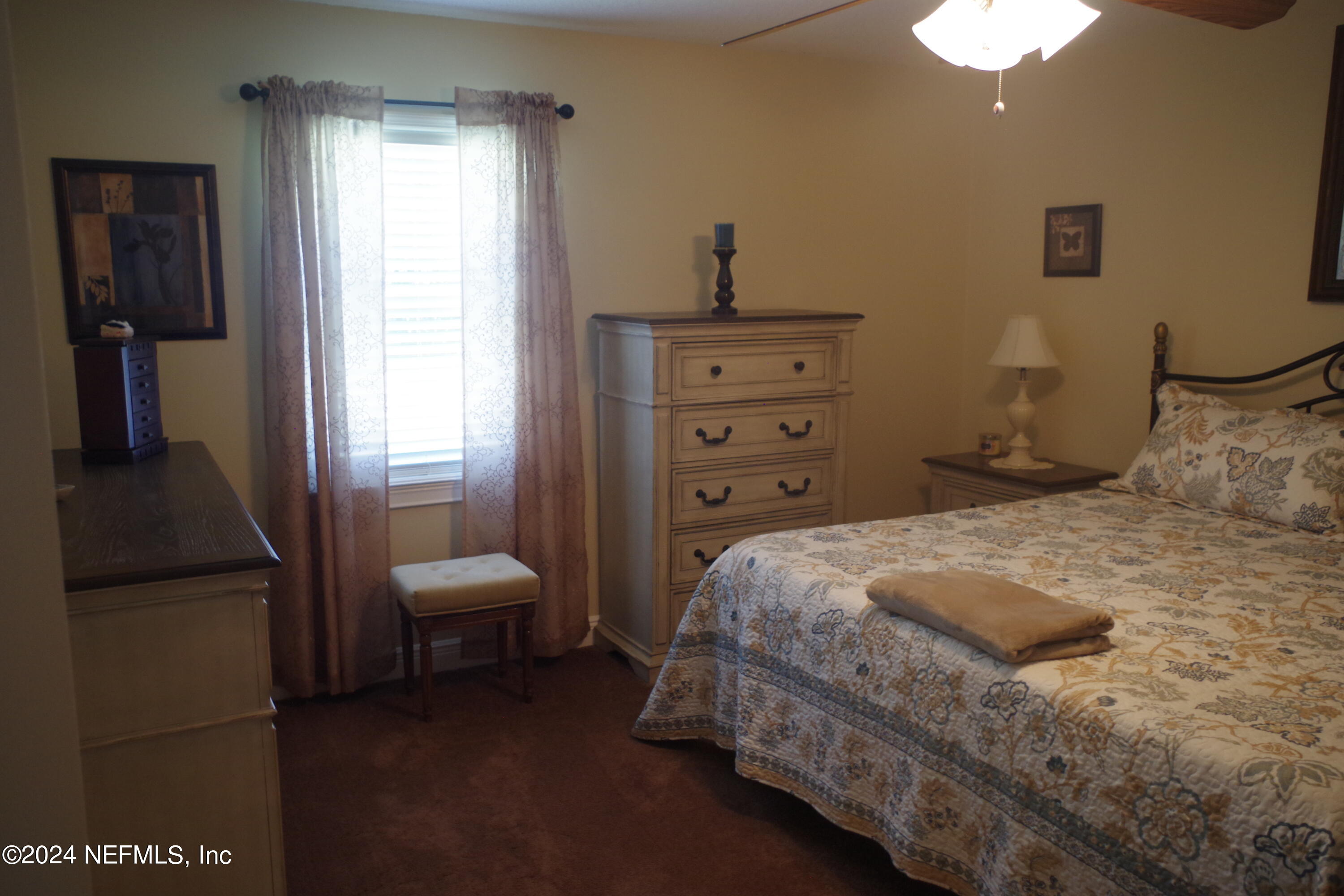 54065 Howard Road Callahan, FL 32011 - Photo 50 of 69 a bedroom with a bed and a chandelier