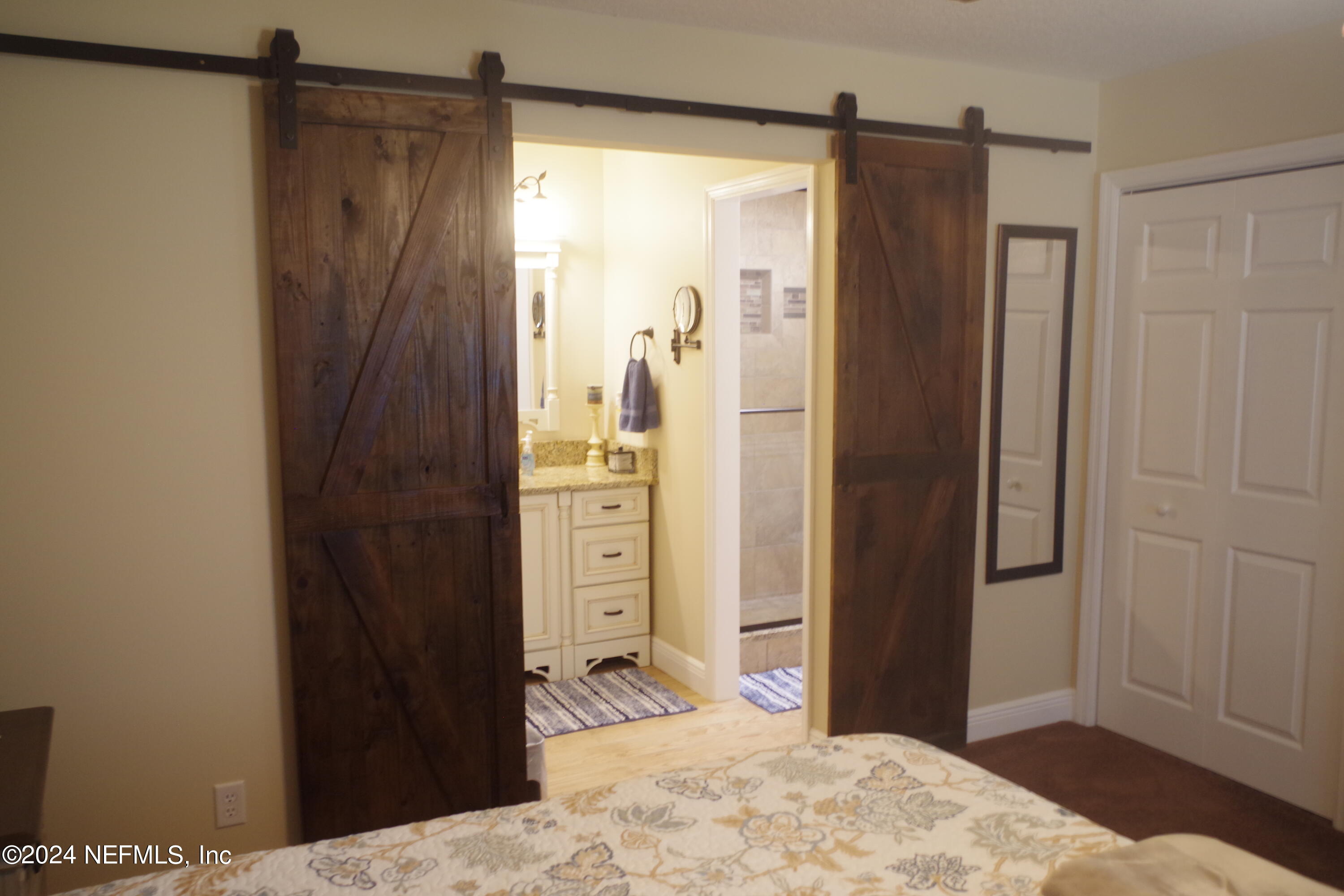 54065 Howard Road Callahan, FL 32011 - Photo 52 of 69 a bedroom with a bed and a mirror