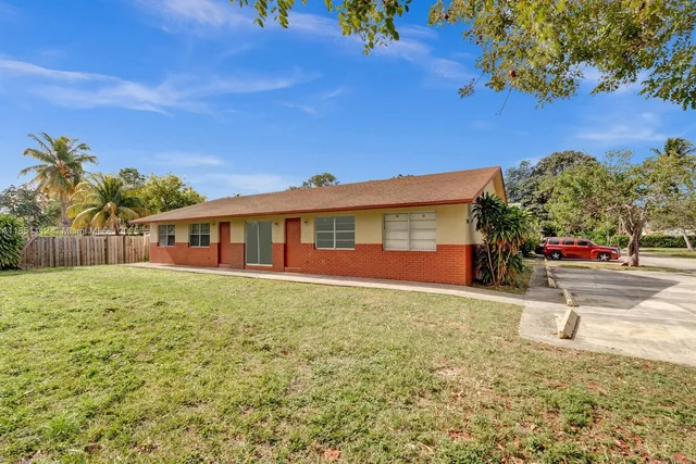 a view of a house with backyard and sitting area