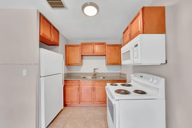 a kitchen with a refrigerator sink stove and cabinets