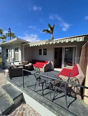 a view of a patio with couches and table and chairs under an umbrella