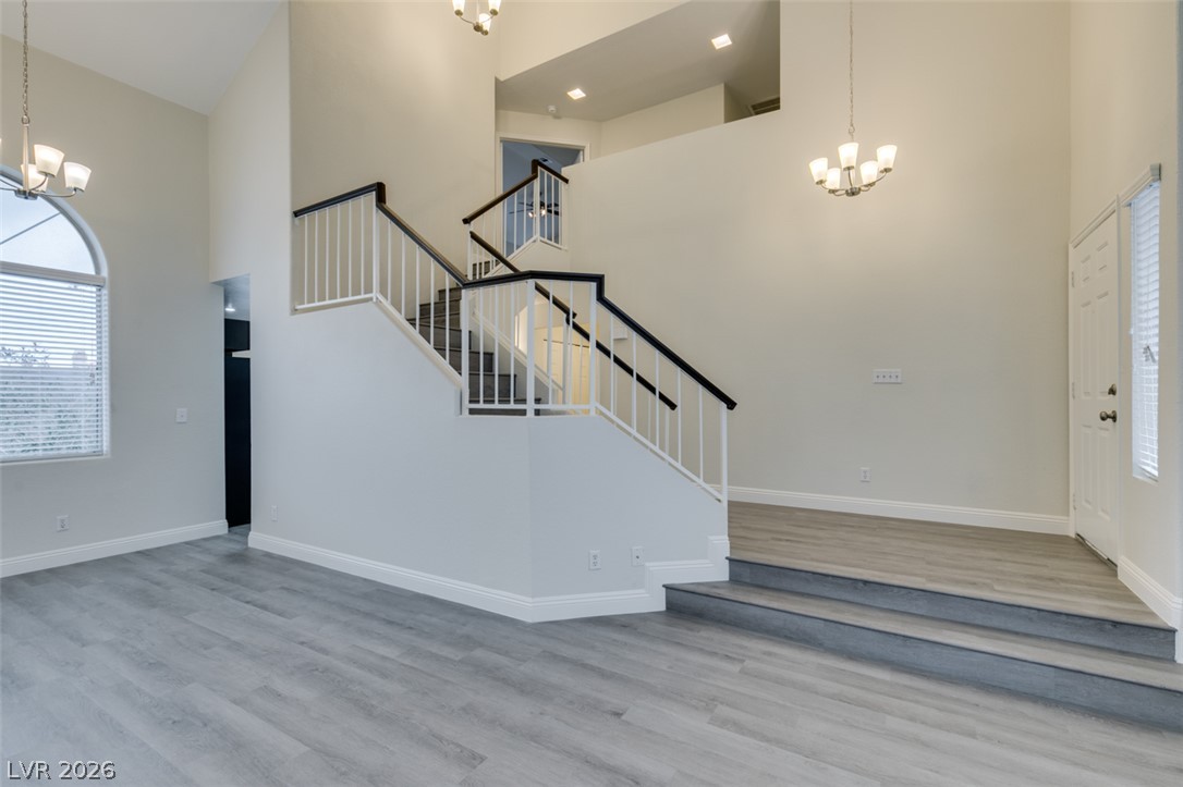 1738 Toltec Circle Henderson, NV 89014 - Photo 36 of 46 Dramatic vaulted ceilings crown this inviting entry and living area, showcasing sleek flooring and a grand staircase.