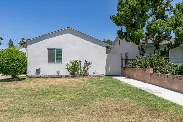 a view of a house with a yard and potted plants