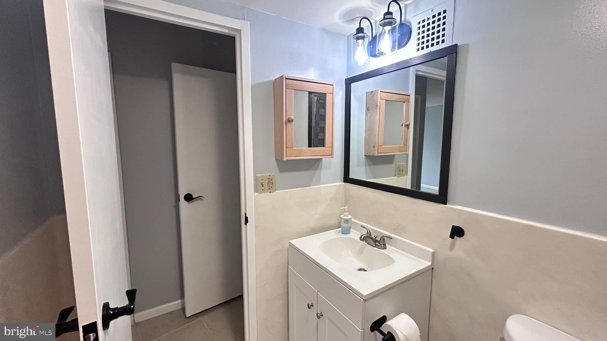 1239 Vermont Avenue Northwest, Unit 204 Washington, DC 20005 - Photo 20 of 39 a bathroom with a sink a toilet and mirror