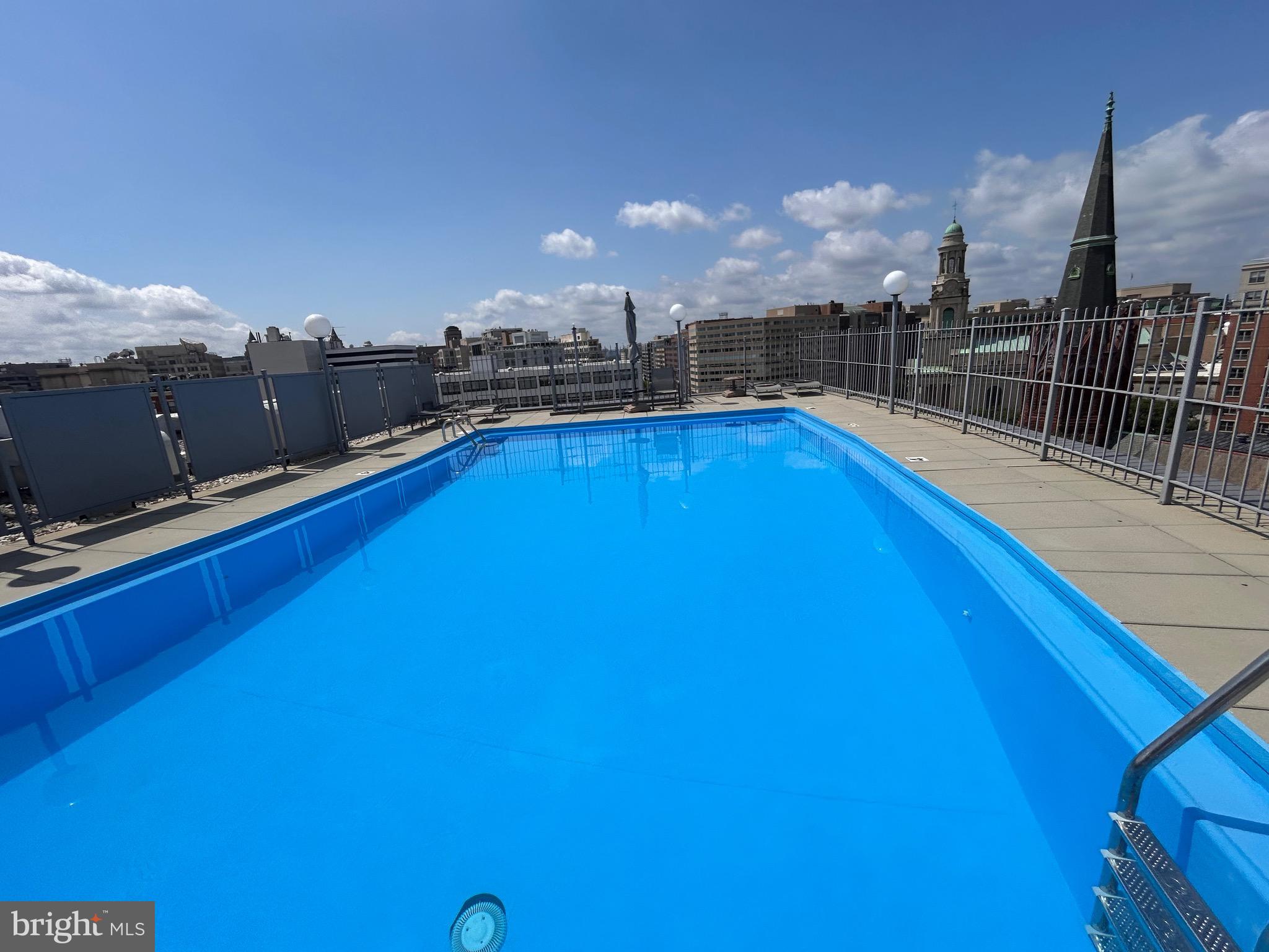 1239 Vermont Avenue Northwest, Unit 204 Washington, DC 20005 - Photo 23 of 39 a view of a swimming pool with a table and chairs