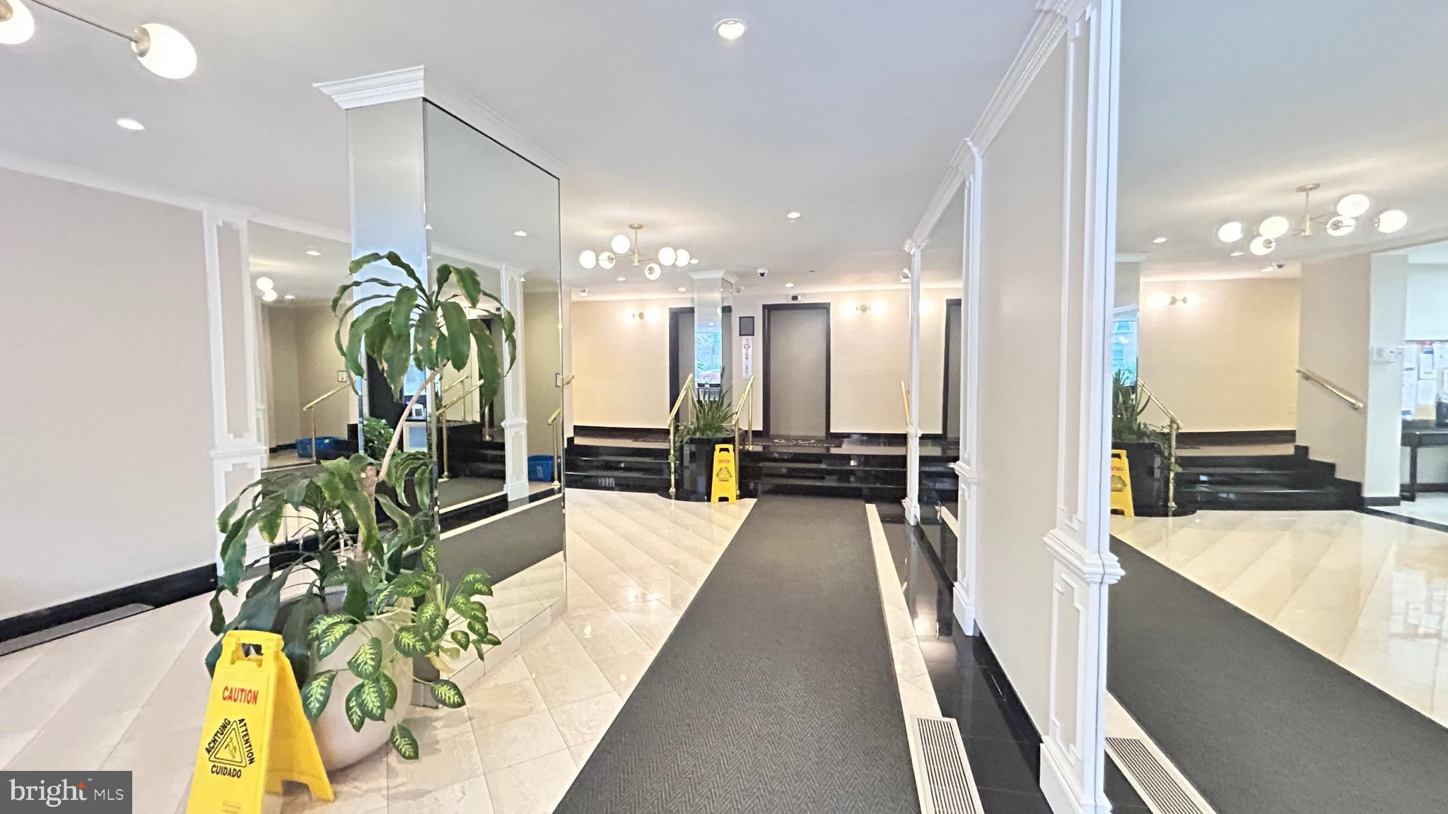 1239 Vermont Avenue Northwest, Unit 204 Washington, DC 20005 - Photo 39 of 39 a large white kitchen with a large counter top and stainless steel appliances