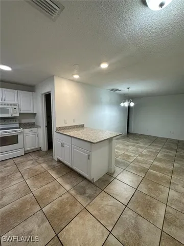 a large kitchen with granite countertop a stove a sink and a refrigerator