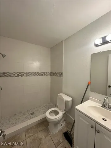 a bathroom with a granite countertop toilet a sink and a mirror