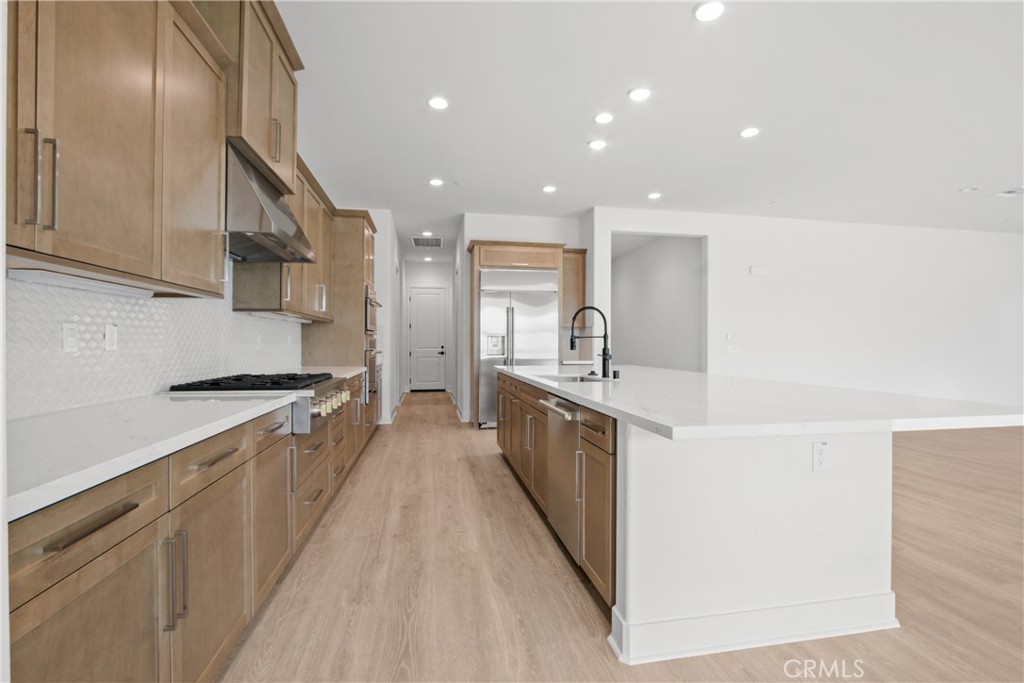 4685 Avondale Court Chino, CA 91710 - Photo 6 of 16 a kitchen with stainless steel appliances a sink stove and cabinets