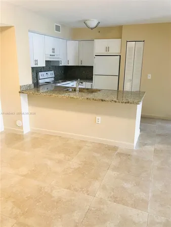 a view of a kitchen with kitchen island and stainless steel appliances