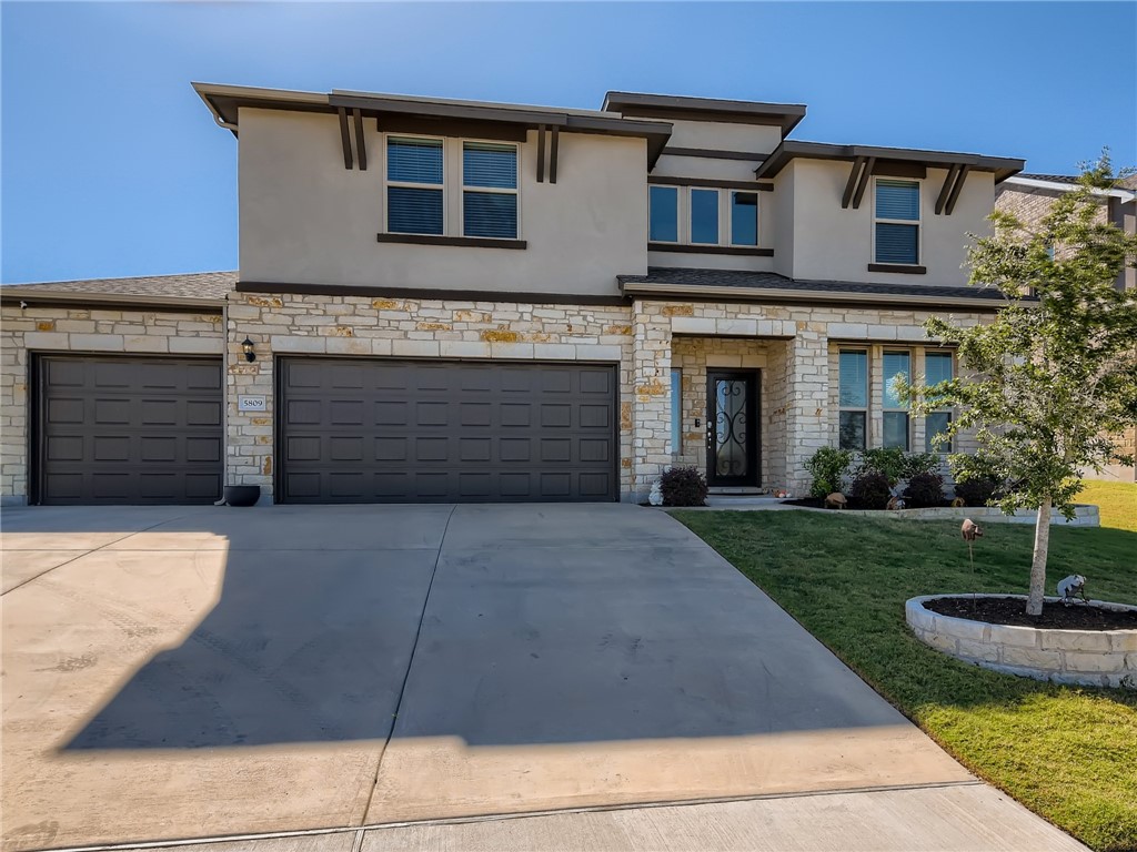 a front view of a house with a yard and garage