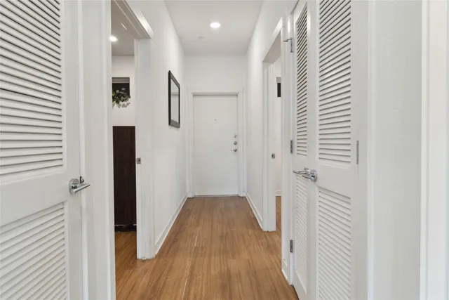 a view of a hallway with wooden floor and staircase
