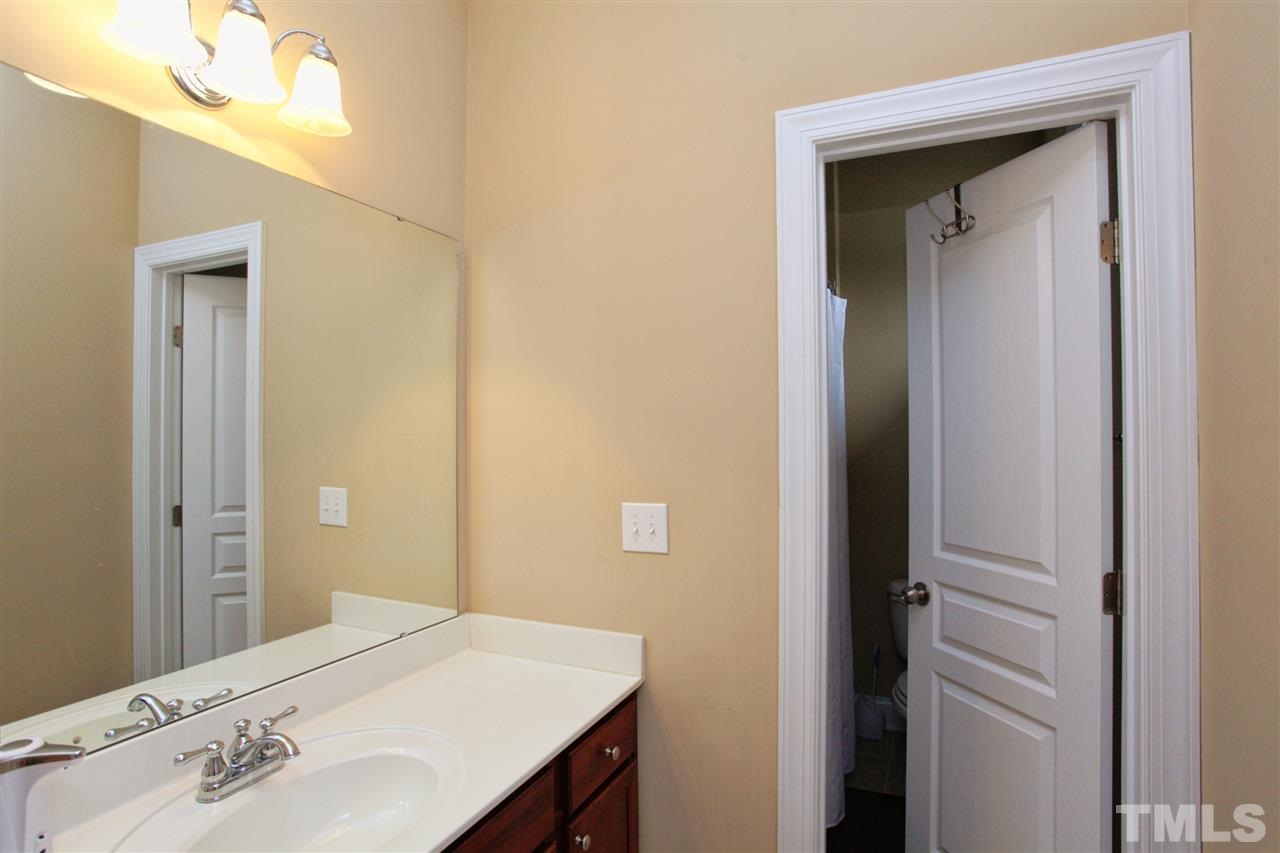 618 Democracy Street Raleigh, NC 27603 - Photo 19 of 24 a en suite bathroom with a sink and a mirror