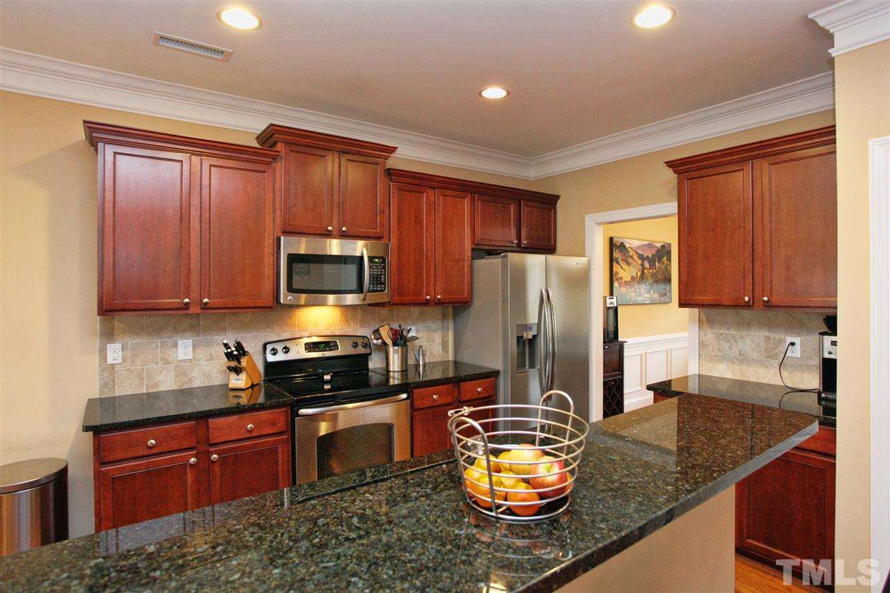618 Democracy Street Raleigh, NC 27603 - Photo 7 of 24 a kitchen with granite countertop stainless steel appliances a stove a sink a refrigerator a microwave and cabinets