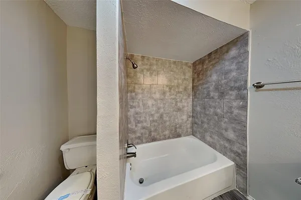 a bathroom with a bathtub and toilet