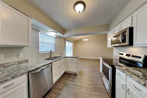 a kitchen with stainless steel appliances granite countertop a sink stove and microwave