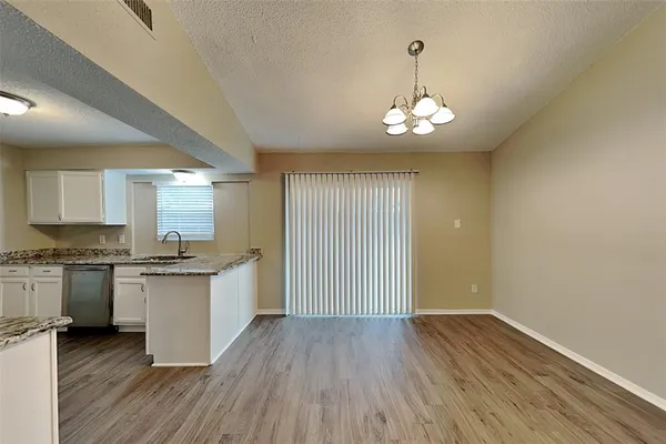 a kitchen with granite countertop stainless steel appliances a stove top oven a sink and dishwasher