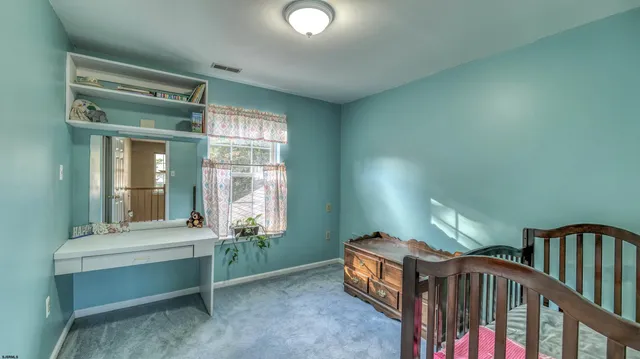 a bedroom with a bed and dresser with mirror