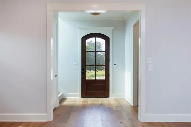 a view of a hallway with wooden floor and entryway