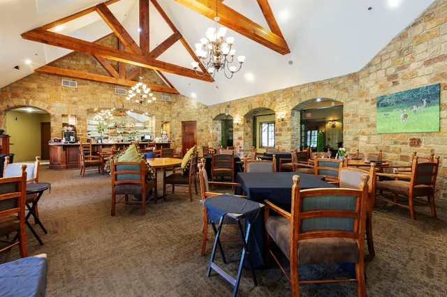 a large room with lots of tables a chandelier and appliances