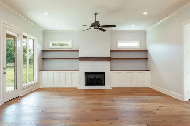 a view of a room with wooden floor and a ceiling fan