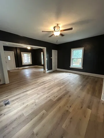 a view of an empty room with window and fireplace