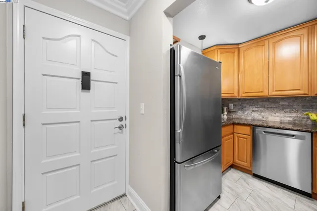 a kitchen with stainless steel appliances granite countertop a refrigerator and a stove top oven