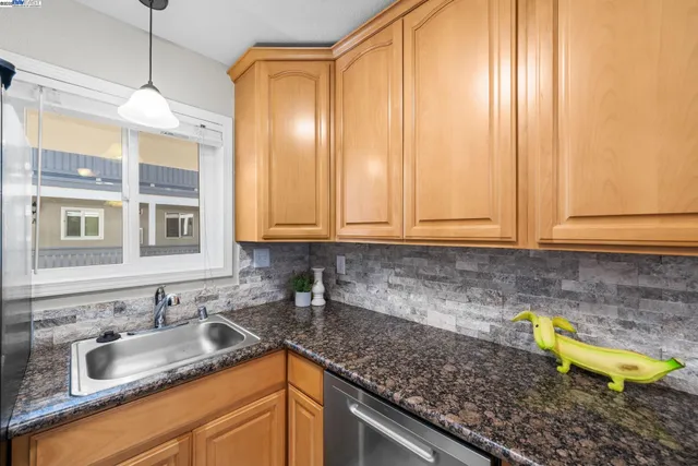 a kitchen with granite countertop a sink stainless steel appliances and cabinets