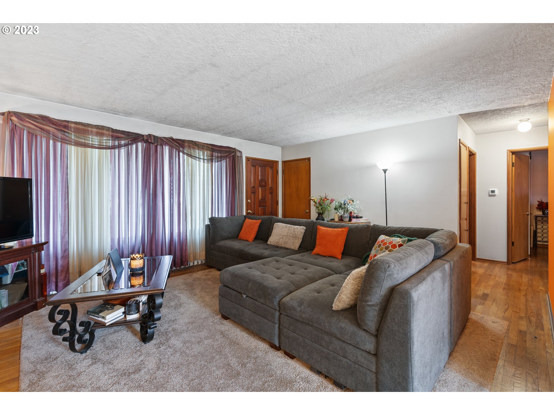 3832 North Kilpatrick Street Portland, OR 97217 - Photo 17 of 34 a living room with furniture a flat screen tv and a large window