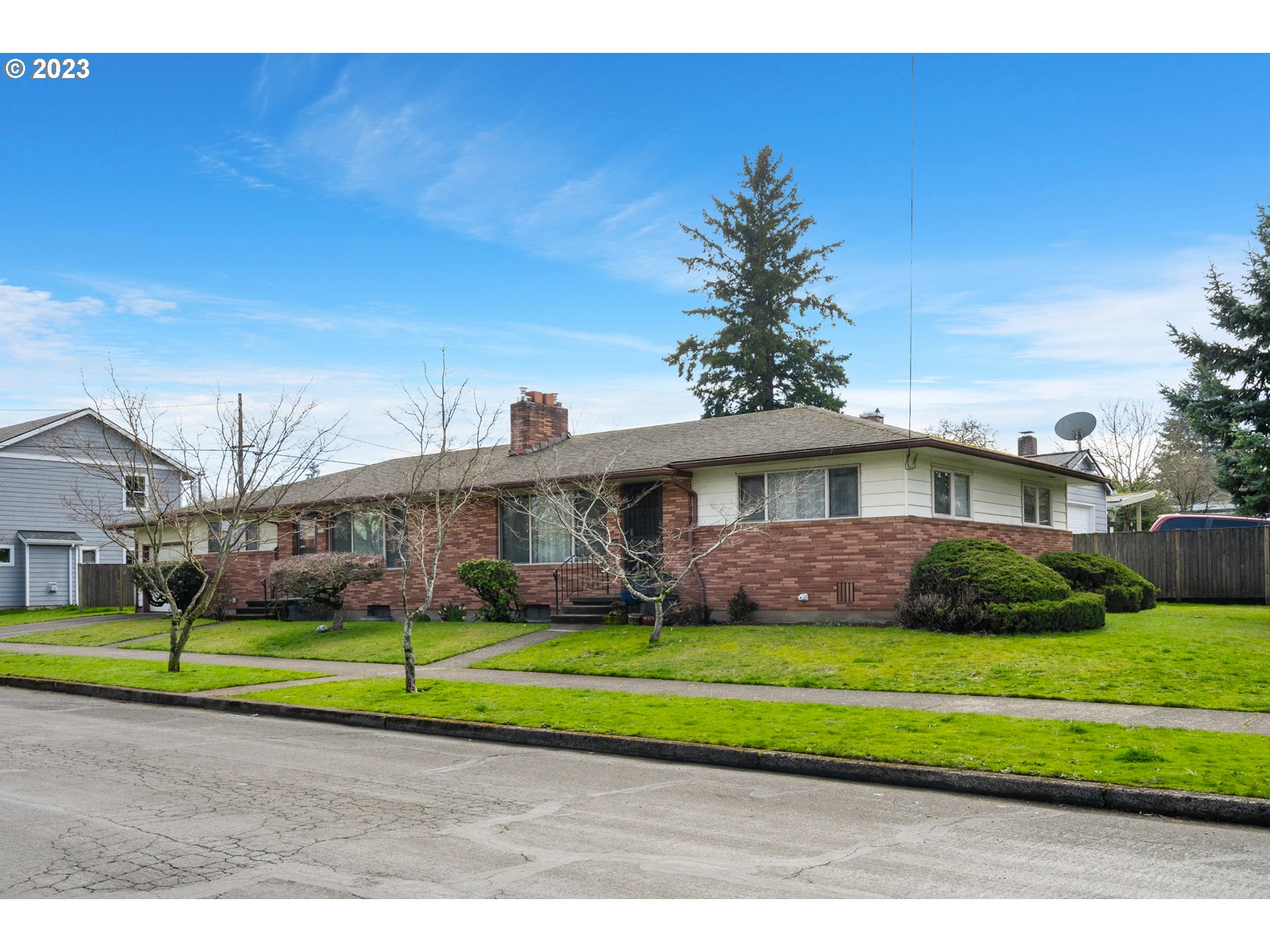 3832 North Kilpatrick Street Portland, OR 97217 - Photo 3 of 34 a view of a big house in a big yard with plants and large trees