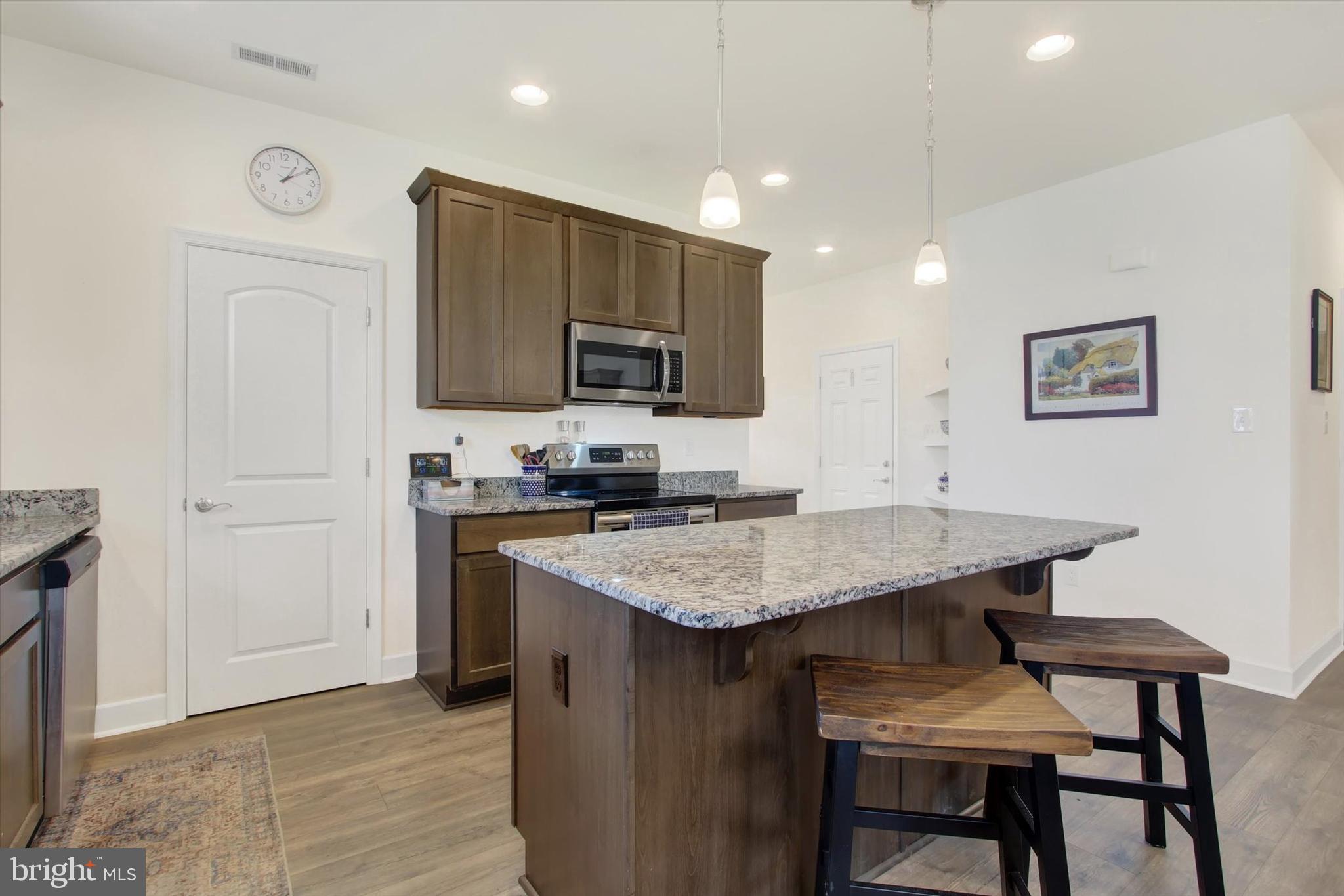 8 Osprey Court Gettysburg, PA 17325 - Photo 6 of 26 a kitchen with stainless steel appliances granite countertop a stove a sink a microwave a refrigerator and white cabinets with wooden floor