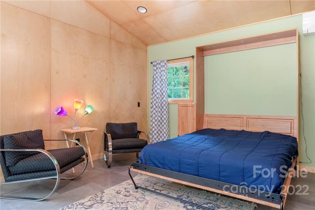 450 Lakey Gap Road Black Mountain, NC 28711 - Photo 32 of 40 a bedroom with a bed a couch and a window