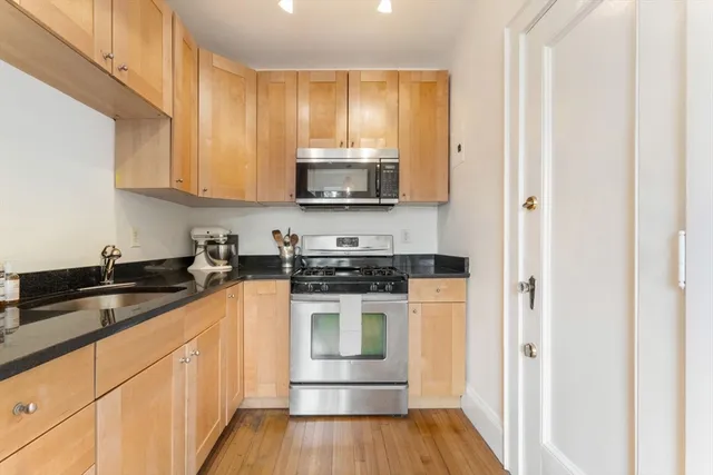 a kitchen with stainless steel appliances granite countertop a stove a sink and a refrigerator